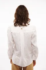 Camisa blanca de lino con cuello clásico, mangas largas con volumen y frunces en los hombros.