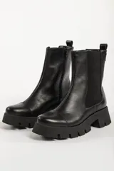 Bota tipo chelsea de caña media, color beige, con paneles laterales elásticos y suela track de plataforma dentada.