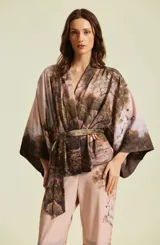 Kimono de mujer con silueta amplia y envolvente, mangas murciélago y lazo para ajustar en la cintura. Presenta un estampado de paisaje editorial con caballos.