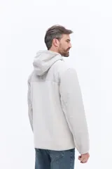 Campera polar con cierre frontal, diseño de paneles en color verde oliva y marrón, con capucha integrada y bolsillos laterales.