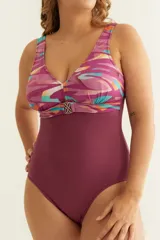 Malla entera color borgoña con escote en V, breteles anchos y aplique metálico dorado en el centro.