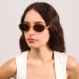 Lentes de sol con armazón metálico dorado y diseño ovalado. Cuentan con cristales oscuros con protección UV400.