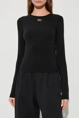 Remera Diesel de manga larga y corte ceñido al cuerpo, de color negro, con cuello redondo y el logotipo metálico ovalado de la marca en el centro del pecho.