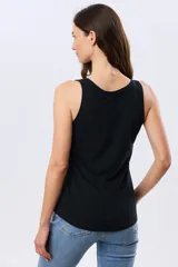 Musculosa básica lisa color beige, con escote redondo y tapeta frontal con tres botones.