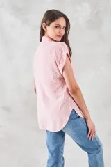 Blusa de viscosa con estampado de rayas verticales en color blanco y rosado, cuello camisero, cierre frontal con botones y mangas cortas con dobladillo.