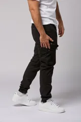 Pantalón cargo color beige de gabardina, con corte ajustado, bolsillos laterales con fuelle y puños elásticos en los tobillos.