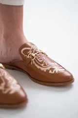 Mocasines color camel con detalle de tigre bordado en hilo color crema y aplique metálico dorado.