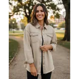 Campera tipo sobrecamisa de jean en color naranja, con corte oversize, cuello italiano, cierre frontal con botones metálicos y ruedo deshilachado. Cuenta con bolsillos frontales con solapa y mangas largas.