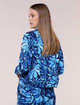 Camperita liviana de silueta entallada, con estampado floral en tonos azules, cuello camisero, cierre frontal con botones y bolsillos en el pecho.