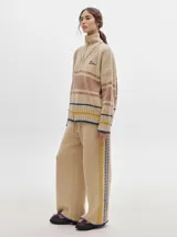 Pantalón de jogging rojo con textura tipo terciopelo, calce ancho y suelto, con detalle de pespuntes a los lados.