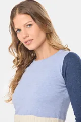 Buzo tejido de punto con diseño de bloques de color, cuerpo en tono celeste melange y mangas largas en azul marino. Presenta una franja inferior en tono beige con textura acanalada y cuello redondo.