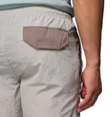 Pantalón cortavientos Columbia Challenger Windbreak Omni-Shield en color gris con paneles laterales en verde oliva y marrón, con dobladillo ajustable mediante cordón elástico.