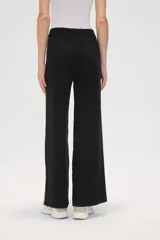 Pantalon de tejido de punto color crema, de corte ancho y tiro alto. Presenta una franja lateral con estampado animal print a lo largo de ambas piernas.