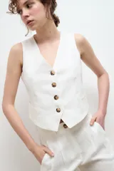 Chaleco sastre color amarillo mostaza, confeccionado en lino con forro de algodón y cierre frontal con botones.