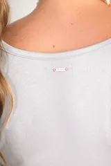 Remera plateada de poliéster y elastano, de corte ajustado y mangas cortas con volados.