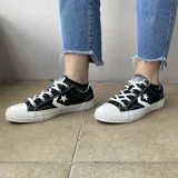 Championes urbanos Converse Star Player, color negro con detalles en blanco, confeccionados en lona, con logo de estrella y galón característico en los laterales.