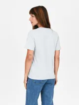 Remera de algodón color celeste con estampa frontal circular que incluye texto y diseño floral.