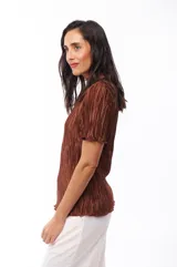 Blusa marrón de poliéster con textura plisada, cuello redondo y mangas cortas con volados.