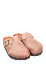 Zueco de cuero color beige con diseño de punta cerrada, ajuste mediante hebilla metálica dorada en el empeine y suela de corcho con base de goma.