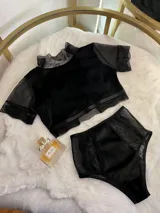 Conjunto de lencería compuesto por un top de cuello alto con mangas cortas y una bombacha de tiro alto. Ambas piezas combinan paneles de terciopelo, microtul transparente y detalles de encaje elastizado.