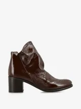 Botín de cuero acharolado negro con taco bloque y punta fina.