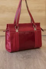 Cartera tipo shopper de cuero genuino marrón con panel central de textura símil cocodrilo y herrajes metálicos plateados.