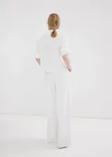 Camisa blanca de corte recto con mezcla de algodón y lyocell, adorno de perlas, cuello camisero, manga larga con puños abotonados y cierre delantero con botones ocultos.