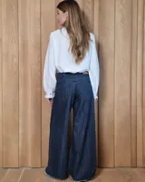 Pantalón de jean estilo wide leg, color azul oscuro, con diseño de pierna ancha y ruedo desflecado.