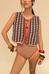 Chaleco tejido a crochet con hilado 100% algodón, con diseño a cuadros en azul y blanco, y terminaciones en verde.