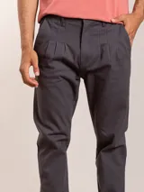 Pantalón bombacha color beige, de sarga, con pinzas en la cintura y corte tapered.