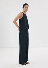 Pantalón largo wide leg de tiro medio confeccionado en tejido de algodón estilo denim, con bolsillos laterales y cierre frontal de botones, gancho y cremallera.