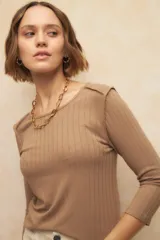 Remera negra de manga tres cuartos, cuello redondo y costuras marcadas en los hombros.