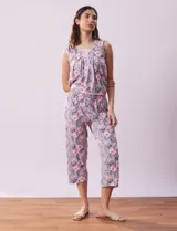 Conjunto de pijama marca René Rofé, compuesto por remera de mangas cortas con escote en V abotonado y pantalón capri con cintura elastizada. Diseño estampado con flores azules sobre fondo blanco.