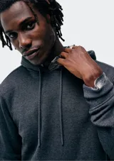 Buzo con capucha de corte clásico, confeccionado en tejido de algodón, con bolsillo frontal tipo canguro y puños acanalados.