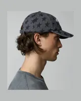 Gorra TwoJeys de color negro con estampado integral de estrellas grises y bordado frontal en color blanco con texto y estrellas.