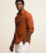 Camisa de hombre de manga larga, color verde oscuro, con cuello camisero y cierre frontal de botones blancos. Corte comfort.