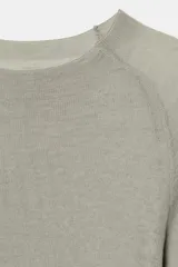 Jersey de punto semitransparente color gris claro, con cuello redondo y manga larga.