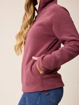Sweater de polar con medio cierre frontal, cuello alto y mangas largas. Presenta un diseño liso en color azul petróleo con un pequeño logo bordado en el pecho.