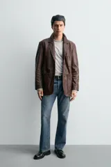 Blazer de corte relajado confeccionada en piel con acabado napado, cuello con solapas de muesca, manga larga, bolsillos frontales de plastrón y cierre frontal de botonadura.