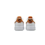 Championes Nike Air Force 1 de corte bajo, color blanco con detalles de estampado animal print de tigre en naranja y negro en el swoosh lateral y en el talón.