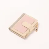 Billetera compacta de mujer, color beige con detalles en gris y rosado. Cuenta con cierre de botón a presión y un bolsillo con cierre de cremallera, adornado con un dije de imperdible dorado.
