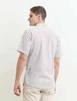 Camisa de manga corta a rayas verticales celestes y blancas, con cuello abotonado y corte clásico.