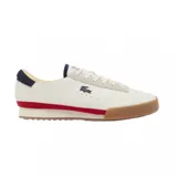 Championes Lacoste modelo Aura, de diseño retro con base de cuero color blanco, detalles en azul marino en el talón y lengüeta, franja lateral roja y suela de goma color caramelo.