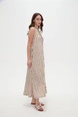 Vestido midi sin mangas de poliéster, color beige con rayas verticales negras, cuello en V y detalle de argolla metálica en el escote.