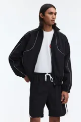Short deportivo negro con bandas laterales blancas, cintura elástica con cordón ajustable blanco y bolsillos laterales.