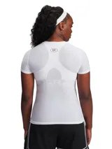 Remera técnica de compresión Under Armour, color blanco, de manga corta y ajuste ceñido al cuerpo. Confeccionada en tejido HeatGear original, diseñado para absorber el sudor y secarse rápidamente, ofreciendo libertad de movimiento y soporte muscular.