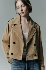 Trench corto de Zara confeccionado en piel de ante, con cuello de solapa, cierre frontal cruzado con botones, mangas largas con trabillas y bolsillos delanteros de vivo.