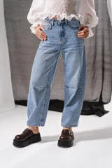 Jean barrel de tiro medio, color celeste con sutil estampado láser, diseño holgado y costuras decorativas en las rodillas.