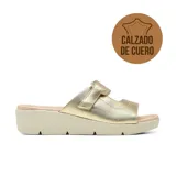 Sandalia de cuero metalizado color dorado, con plataforma baja y tira ancha con ajuste de velcro en el empeine.
