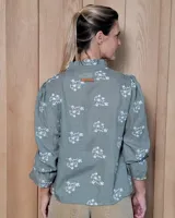 Blusa de algodón con cuello mao y volados, mangas largas con puños elásticos y corte holgado.